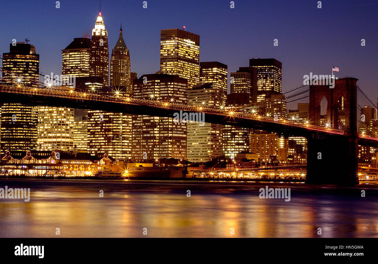Un night shot di una illuminazione Ponte di Brooklyn con un luminoso Manhatan skyline presi dal ponte di Brooklyn Park al crepuscolo Foto Stock