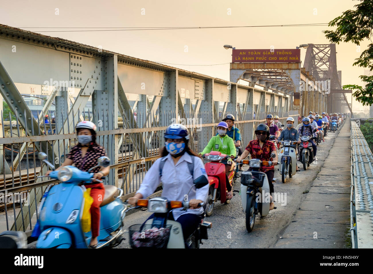 Traffico pesante di pendolari sulla passerella pedonale del ponte a sbalzo Long Bien, con i piloti che utilizzano maschere facciali, Hanoi, Vietnam Foto Stock