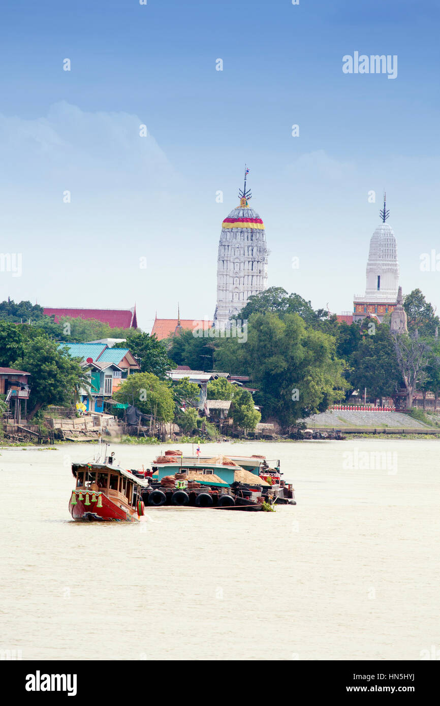 Barcone sul Fiume Chao Phraya in Ayutthaya con stupa del tempio dietro Foto Stock