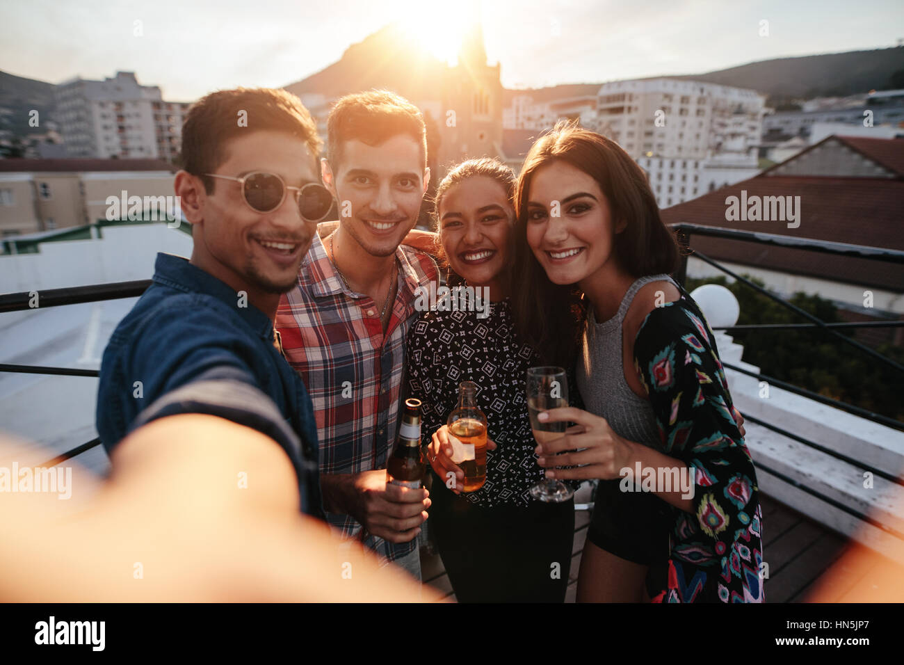 Gruppo di amici prendendo selfie. I giovani sul tetto parte tenendo selfie. Foto Stock Gruppo di amici prendendo selfie. I giovani sul tetto parte tenendo selfie. Foto Stock