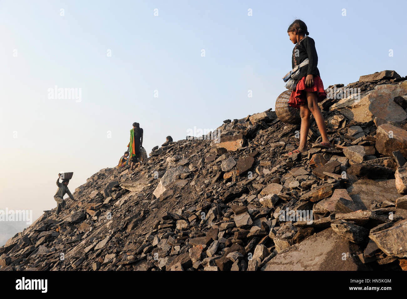 INDIA Jharkhand Dhanbad Jharia, bambini raccogliere il carbone resta da discarica di carbone INDIA a vendere il carbone da coke sul mercato per il sostentamento della sua famiglia, ragazza Sonia 8 anni / INDIEN Jharkand Dhanbad Jharia, Kinder sammeln Kohle auf einer Abraumhalde Am Rande eines Kohletagebaus zum Verkauf als Koks auf dem Markt, Maedchen Sonia 8 Jahre Foto Stock