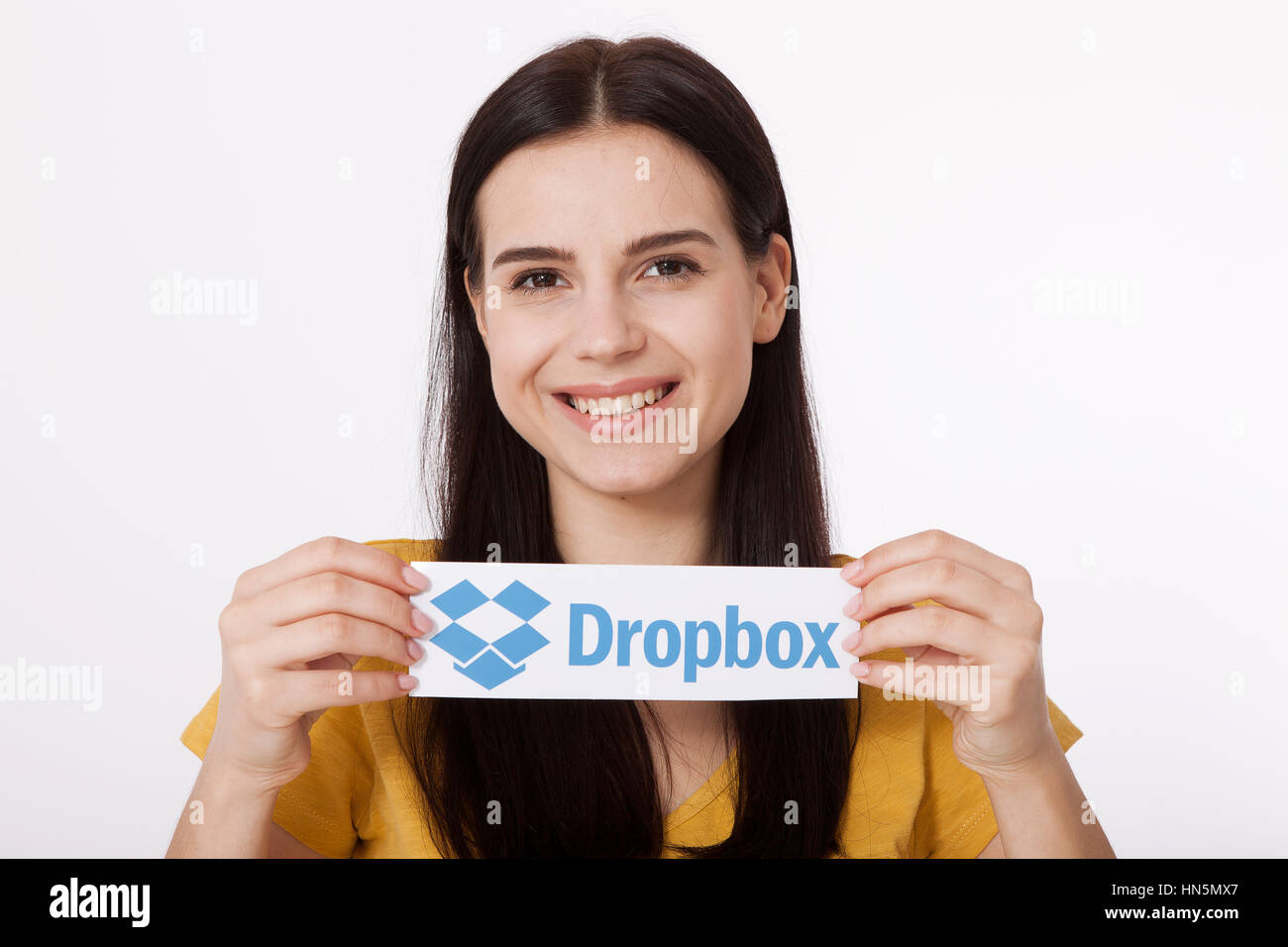 KIEV, UCRAINA - 22 agosto 2016: Donna mani Dropbox logotipo segno stampato su carta su sfondo bianco. Dropbox cloud storage, consentendo agli utenti di archiviare i dati sui server in cloud. Foto Stock