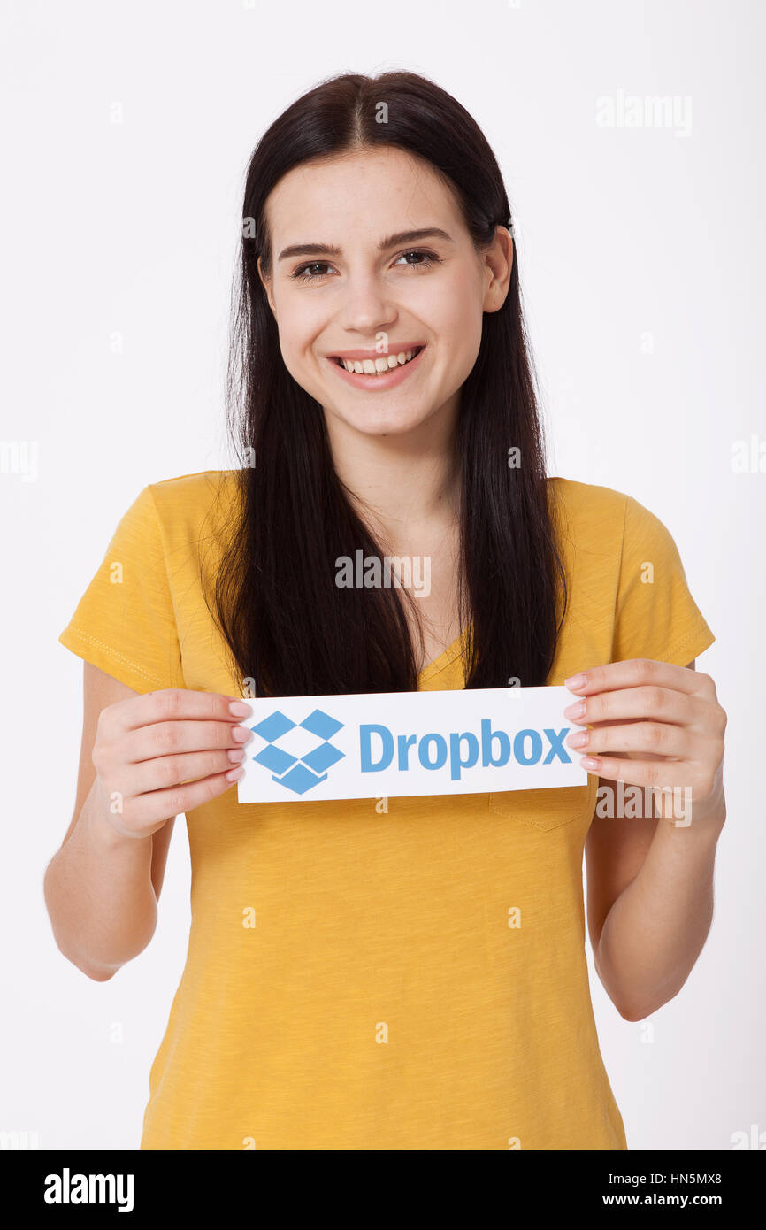 KIEV, UCRAINA - 22 agosto 2016: Donna mani Dropbox logotipo segno stampato su carta su sfondo bianco. Dropbox cloud storage, consentendo agli utenti di archiviare i dati sui server in cloud. Foto Stock