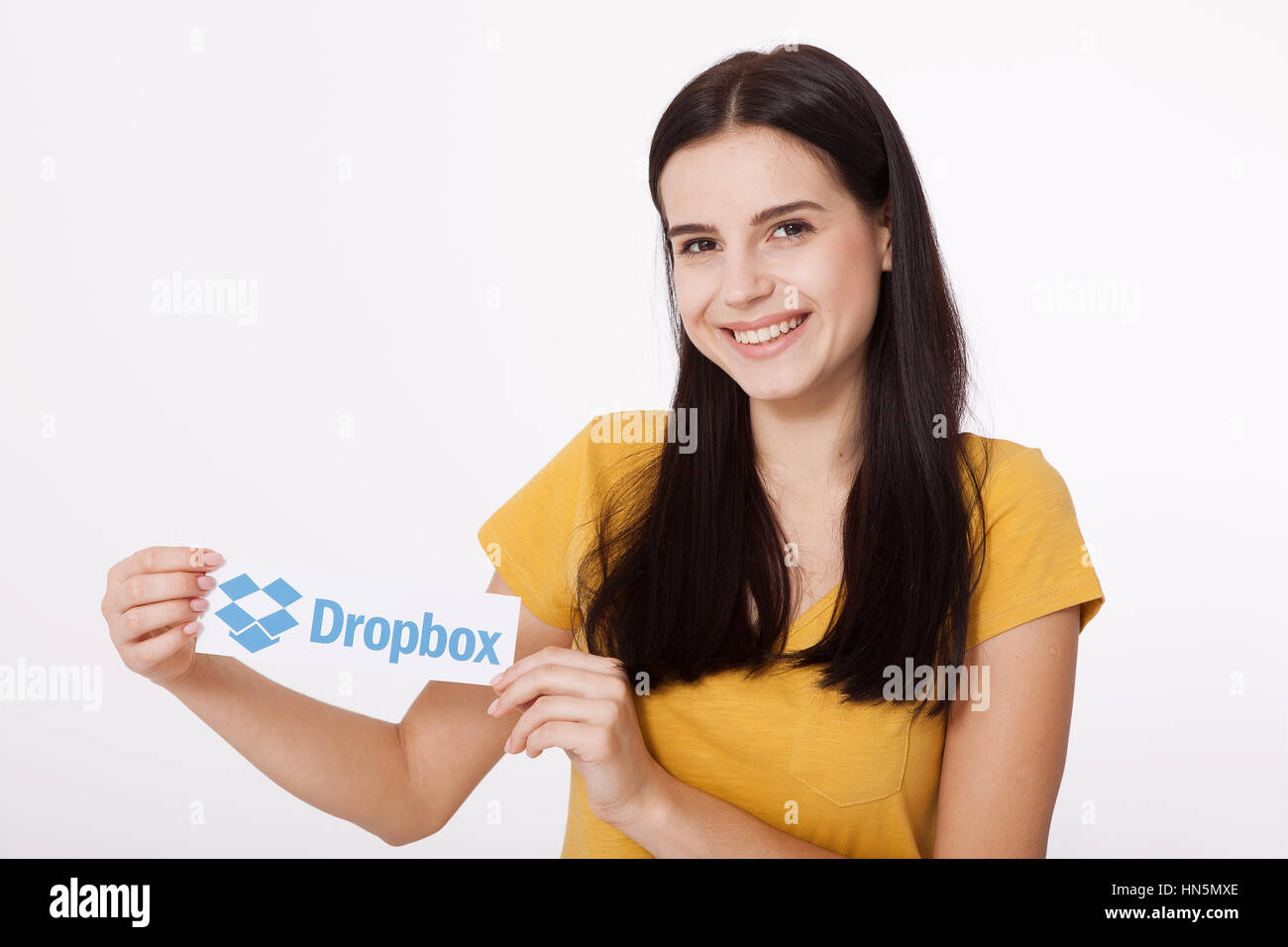 KIEV, UCRAINA - 22 agosto 2016: Donna mani Dropbox logotipo segno stampato su carta su sfondo bianco. Dropbox cloud storage, consentendo agli utenti di archiviare i dati sui server in cloud. Foto Stock