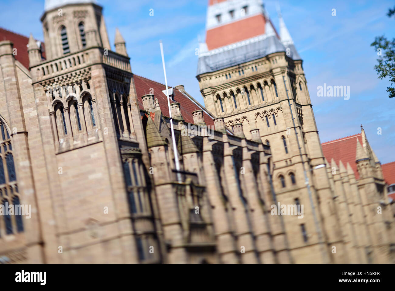 Giornata di sole grandi landmark gotico edificio esterno parte di Manchester University campus, Whitworth Hall sulla principale A34 Oxford Road corridoio del bus Foto Stock