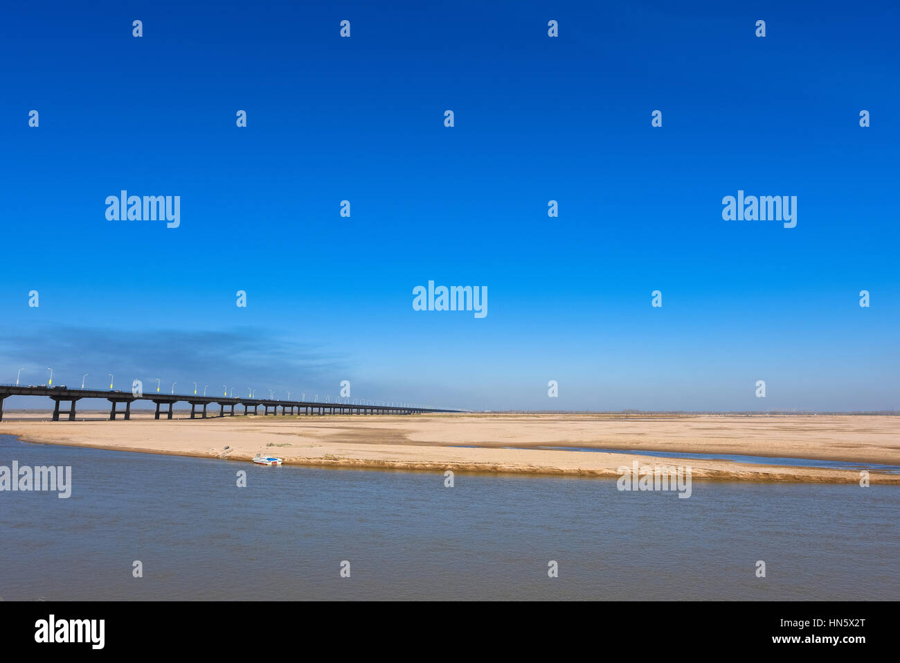 Il Fiume Giallo e ponte con cielo blu in Zhengzhou, nella provincia di Henan, medio della Cina. Si tratta di una parte del vecchio 107 strada nazionale. Foto Stock