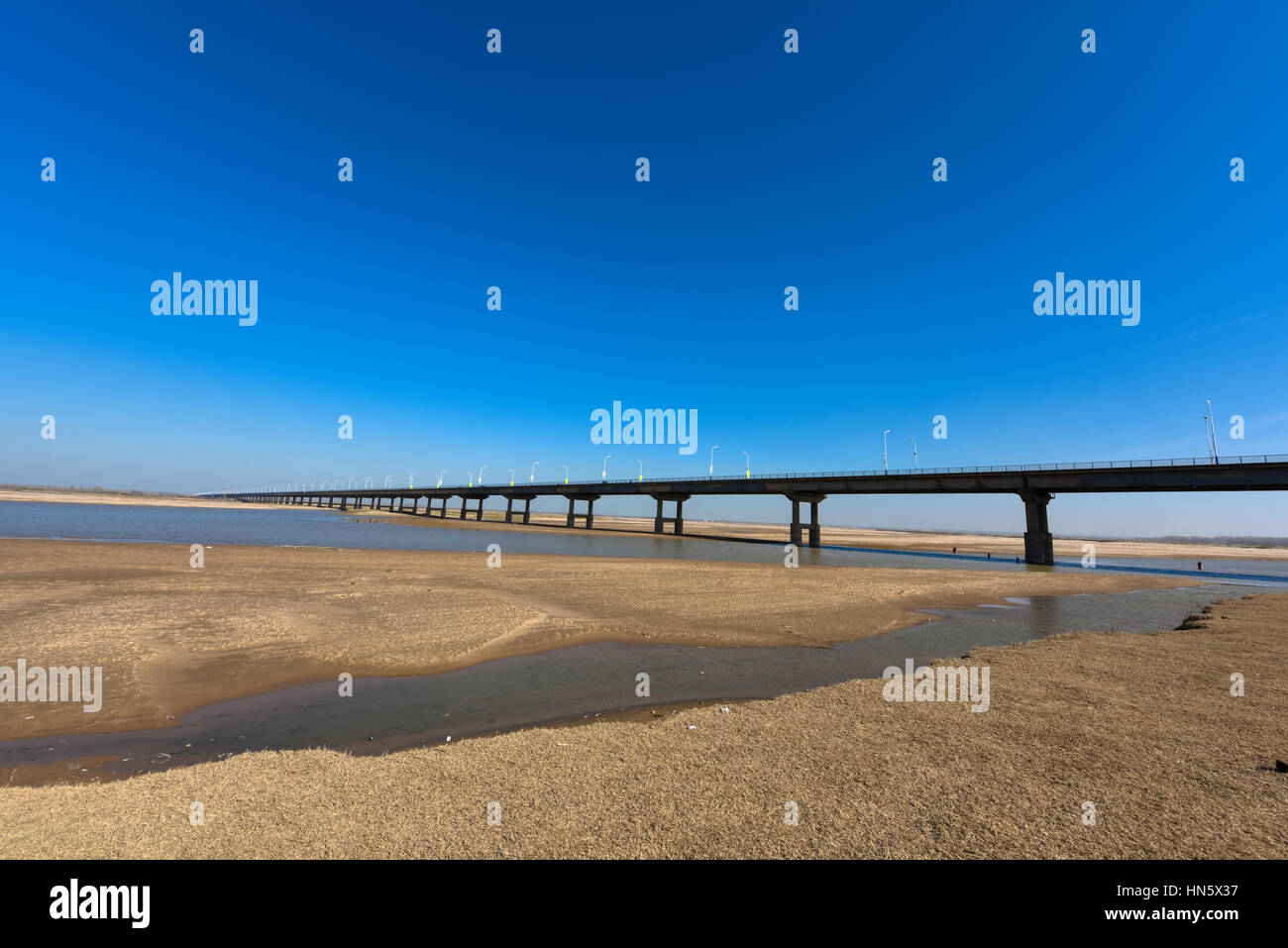 Il Fiume Giallo e ponte con cielo blu in Zhengzhou, nella provincia di Henan, medio della Cina. Si tratta di una parte del vecchio 107 strada nazionale. Foto Stock