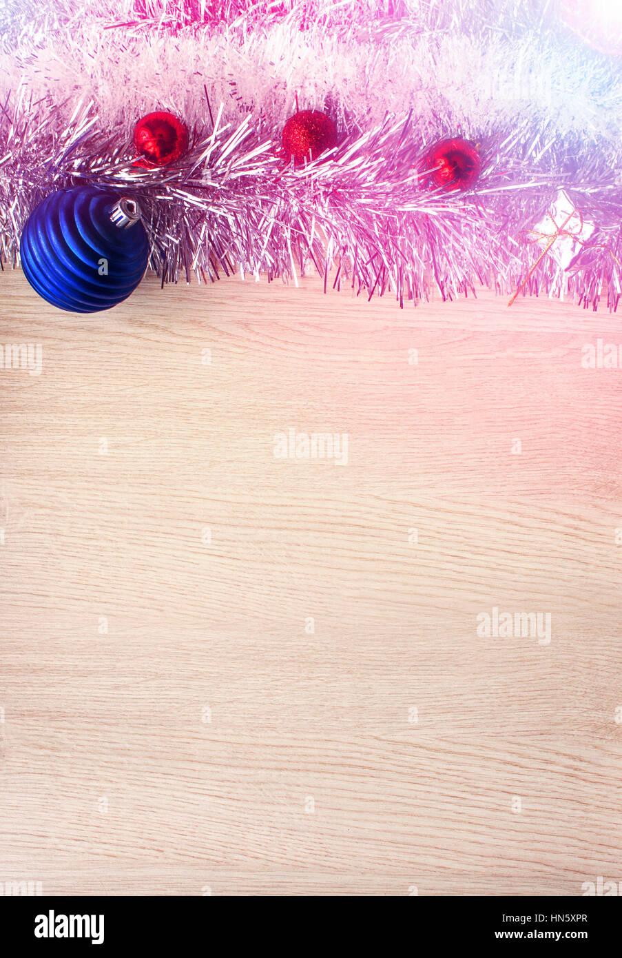 Festa di Natale sfondo. Anno nuovo, palle di Natale, layout su una tavola di legno al substrato. Morbido effetto di illuminazione. Foto Stock