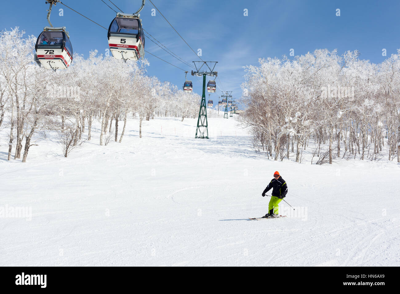 NISEKO, Giappone - 9 marzo : un uomo sci passato una funivia in Niseko Annupuri ski resort il 9 marzo 2012. Niseko è una grande stazione sciistica situata sul Foto Stock
