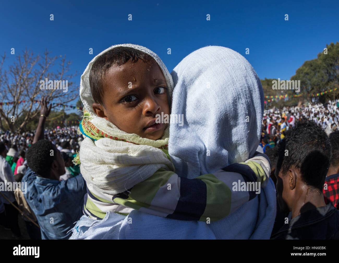 Etiope azienda madre del suo figlio umido dopo aver preso il santo bagno durante Timkat epifania festival, Amhara Region, Lalibela, Etiopia Foto Stock