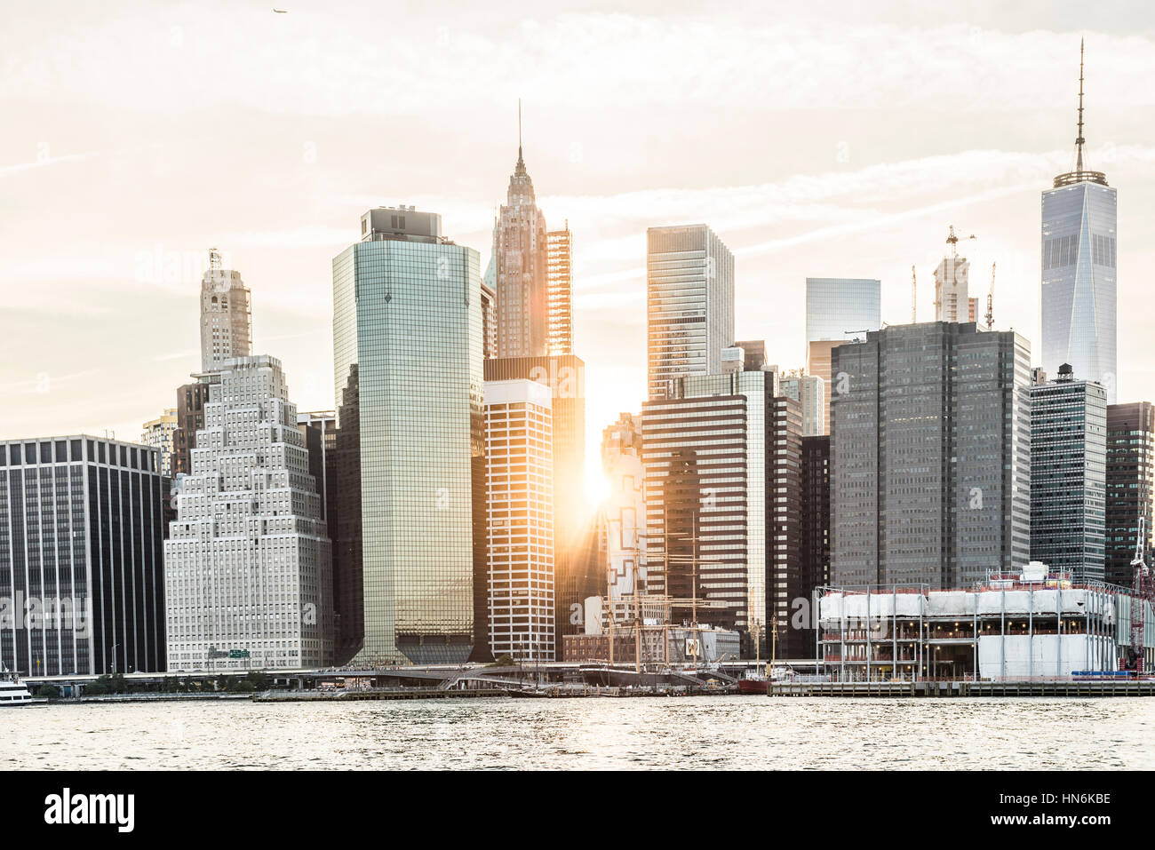 Sunburst tra i grattacieli dello skyline di Manhattan a New York City durante il tramonto Foto Stock