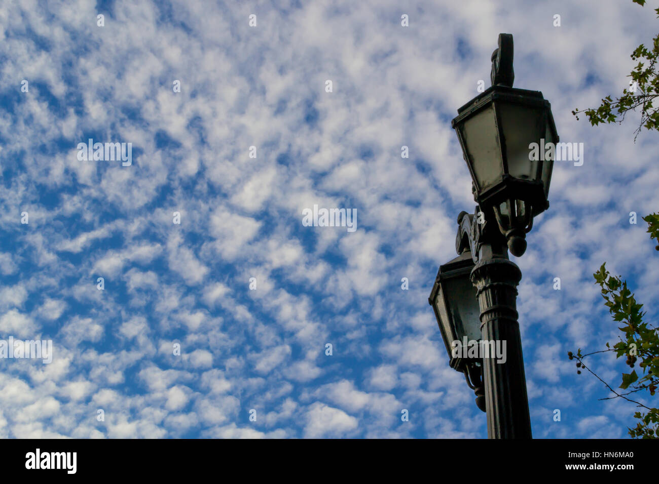 Blu cielo nuvoloso in contrasto con un lampione Foto Stock