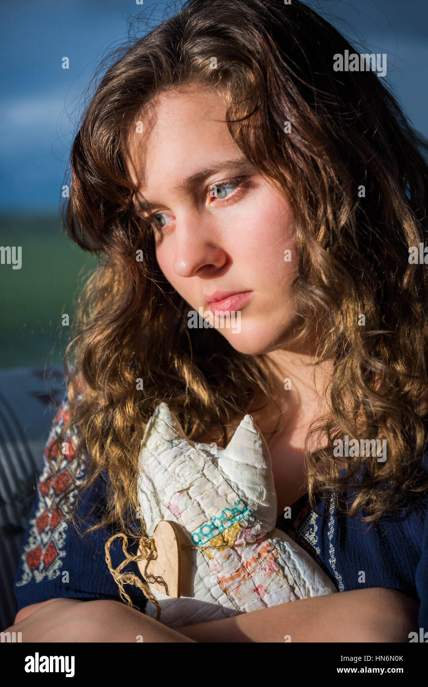 Ritratto di lonely giovane donna guardando triste holding farcite giocattolo cat Foto Stock
