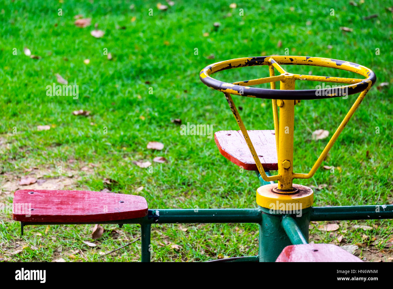 Antica giostra per bambini 4 posti nel parco giochi, fuoco anteriore, sfondo sfocato Foto Stock