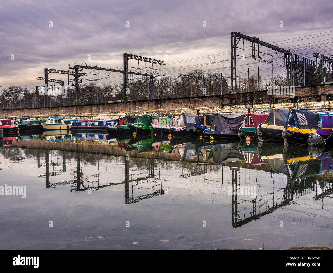 Battelli ormeggiati sul Regent's Canal con linee del treno nella stazione di St Pancras in background, Londra, Regno Unito. Foto Stock