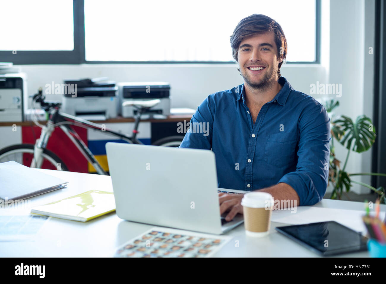 Ritratto maschile di graphic designer che lavora sul computer portatile in ufficio Foto Stock
