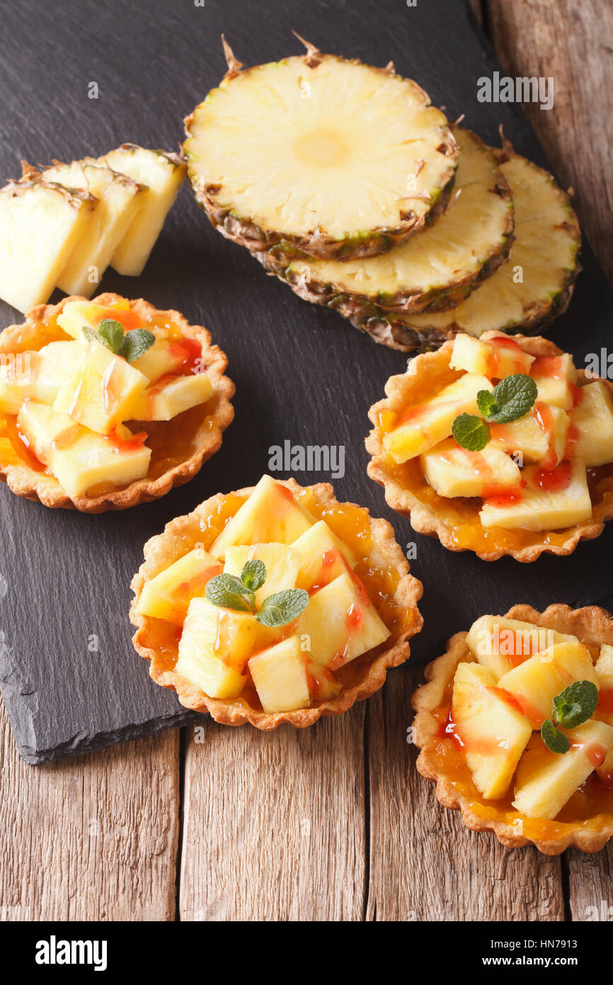Mini crostata con ananas fresco e marmellata closeup sul piano verticale. Foto Stock