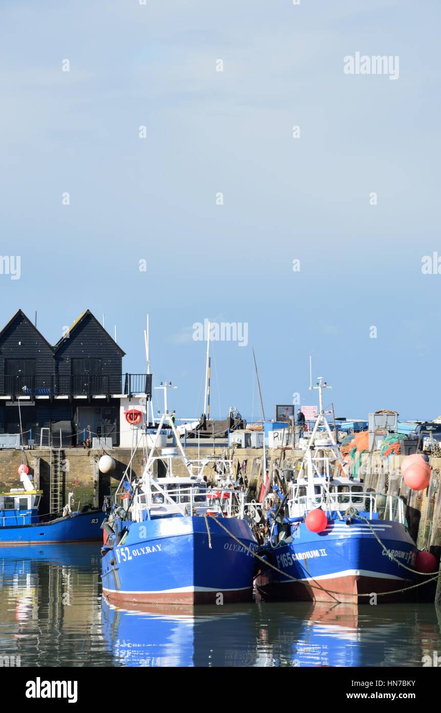 Whitstable, Regno Unito - 1 Ottobre 2016: barche da pesca nel porto di Whitstable in visualizzazione verticale e con il magazzino in background Foto Stock