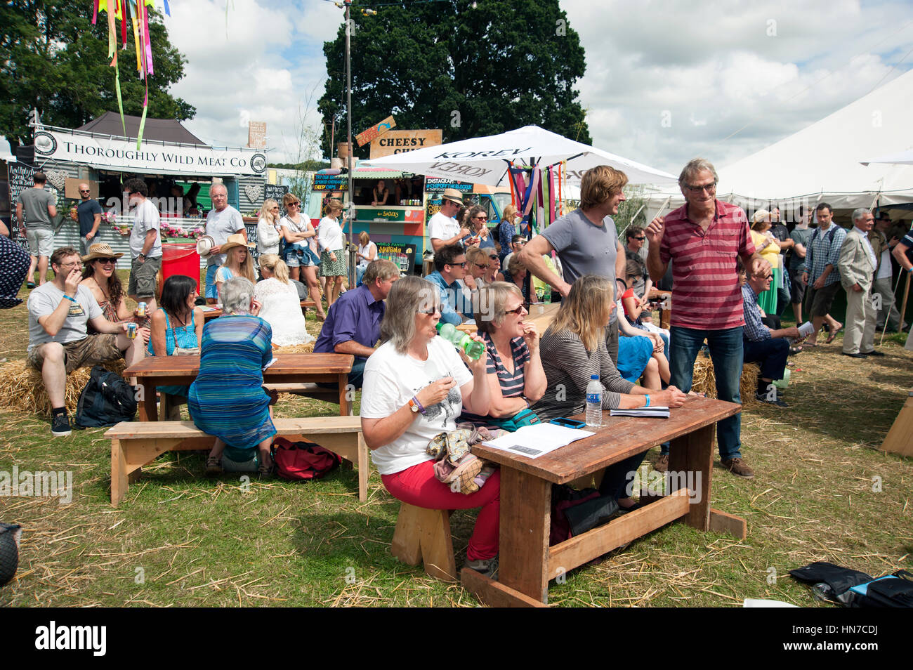 Famiglie seduti ai tavoli del cibo in stallo bere e mangiare presso il porto Eliot Festival Cornovaglia Foto Stock