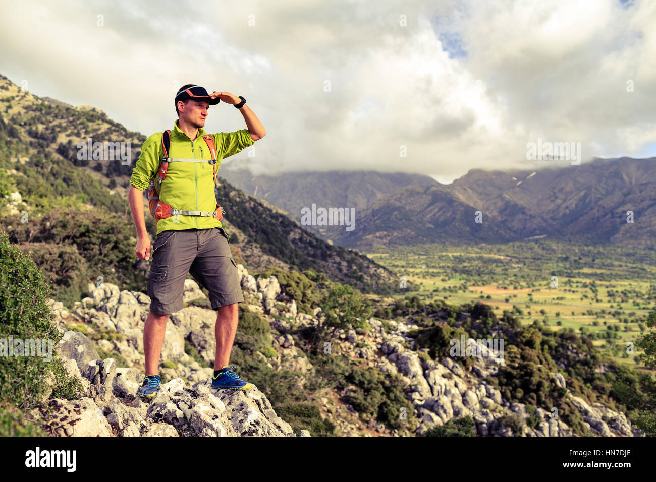 Escursionismo uomo guardando belle montagne paesaggio di ispirazione. Escursionista trekking con zaino sul sentiero roccioso sentiero, ammirando una vista sulla valle. Egli Foto Stock