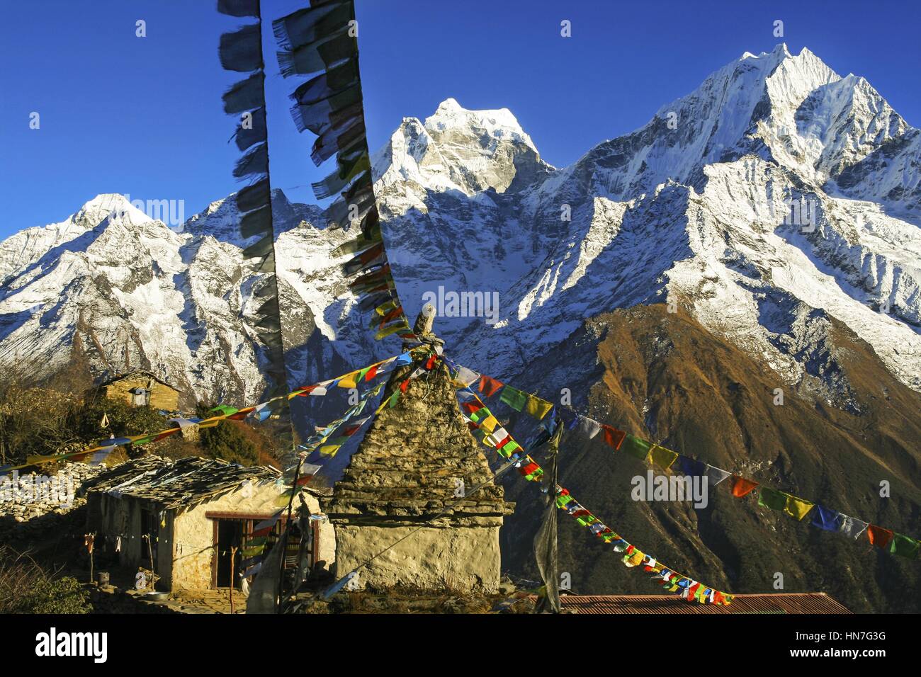 Bandiere di preghiera a Yeti Lodge e lontane vette innevate trekking sul Monte Everest Base Camp in Nepal Himalaya Foto Stock