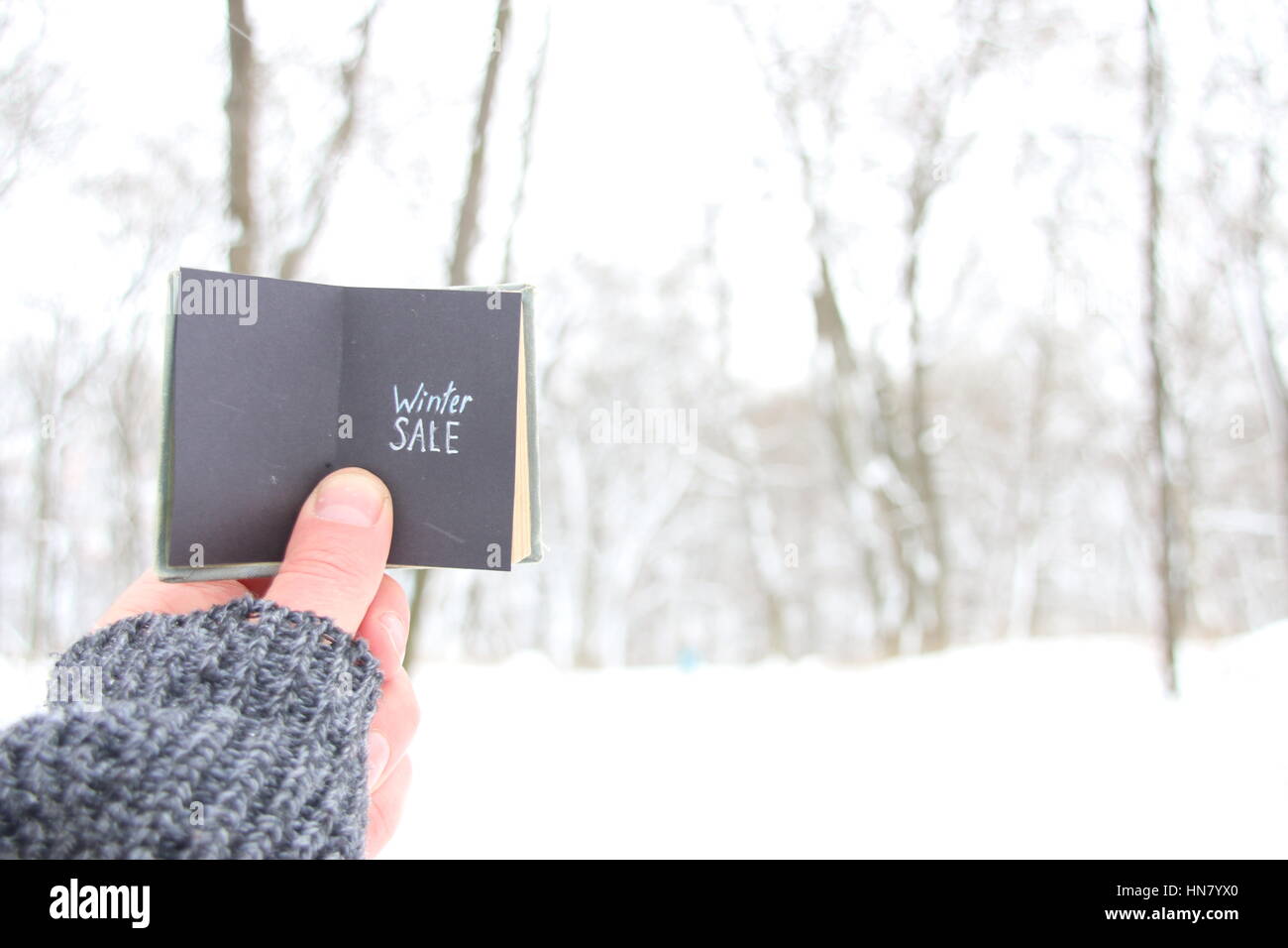 Inverno vendita uomo in possesso di un libro con la scritta Foto Stock