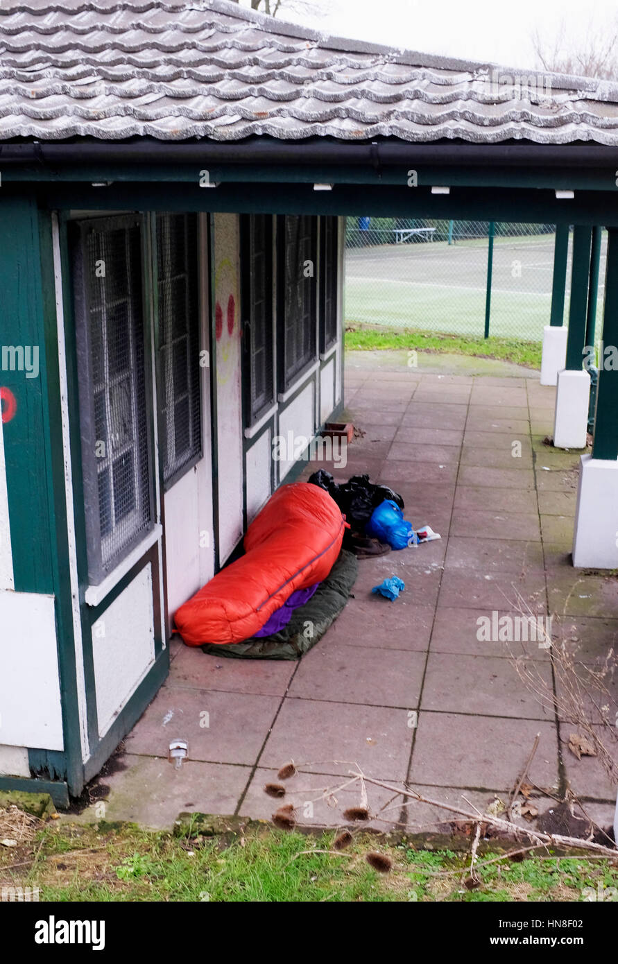 Senzatetto traversina ruvida si rifugiano presso il Queens Park Tennis Club Pavilion a Brighton Regno Unito fotografia scattata da Simon Dack Foto Stock