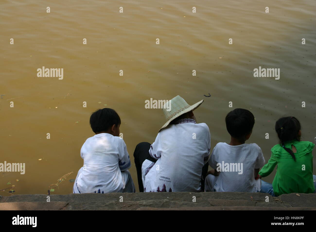 Seduta di famiglia da un lago fangoso in Cambogia Foto Stock