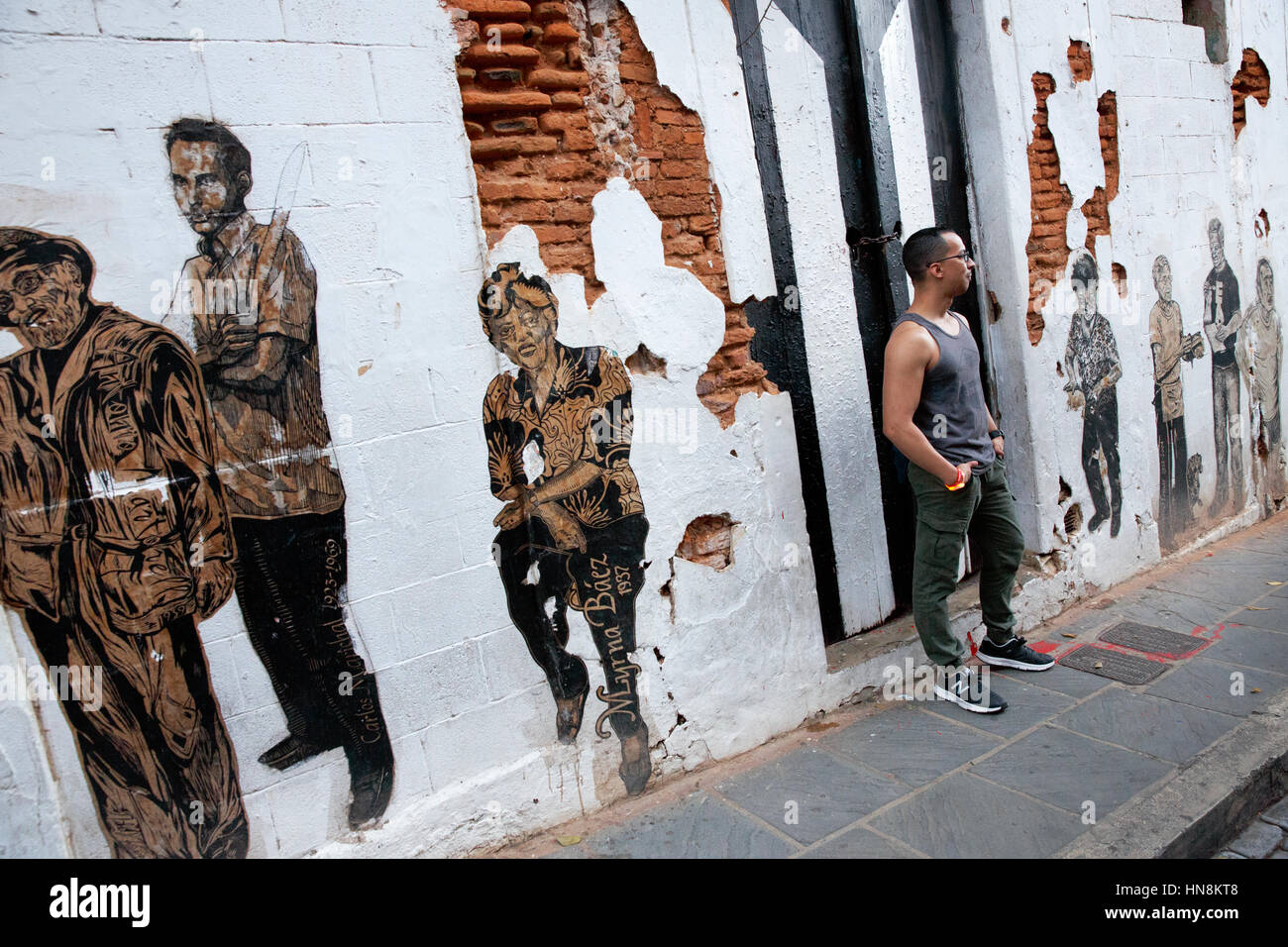Uomo in piedi con muro dipinto murale, San Juan, Puerto Rico Foto Stock