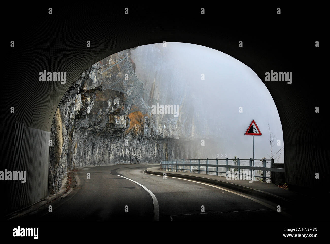 Tunnel roccioso sulla strada a sud del lago di Thun (Thunersee), Oberland bernese, Svizzera Foto Stock
