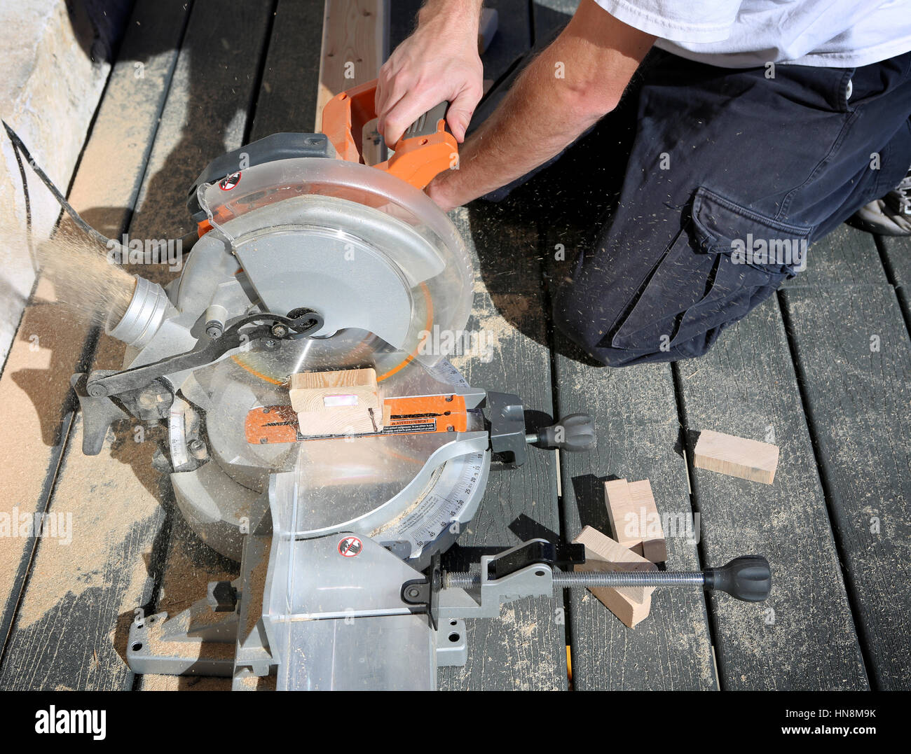 Carpenter utilizzando una sega circolare per tagliare il bordo di legno Foto Stock