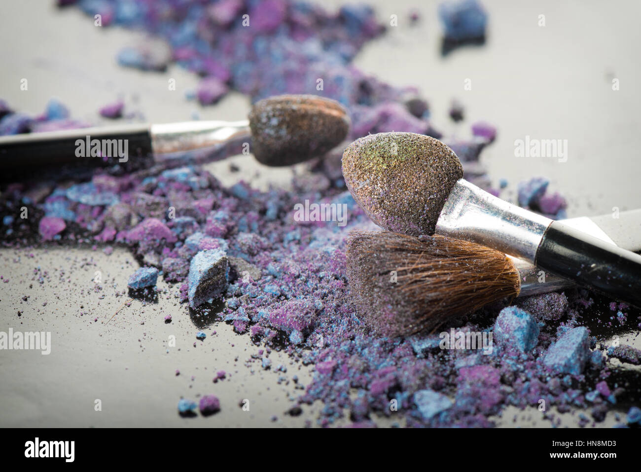 Closeup scadono cosmetici colorati con spazzola Foto Stock