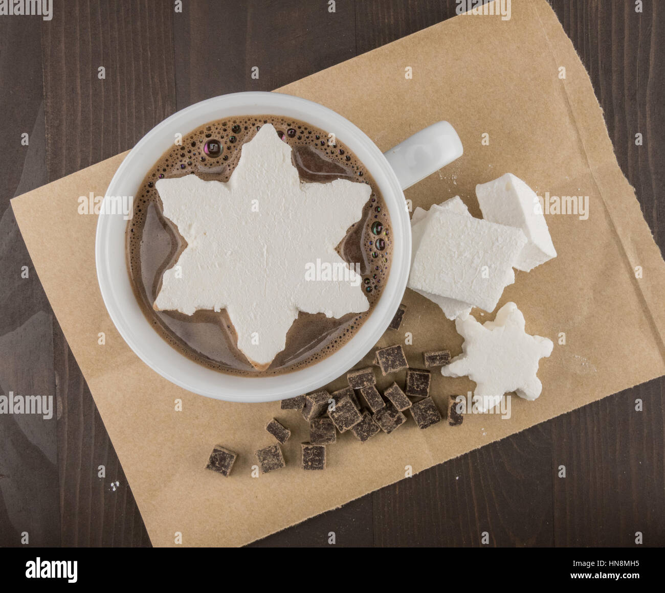 Il simbolo del fiocco di neve Marshmallow nella cioccolata calda in appoggio sulla carta marrone Foto Stock