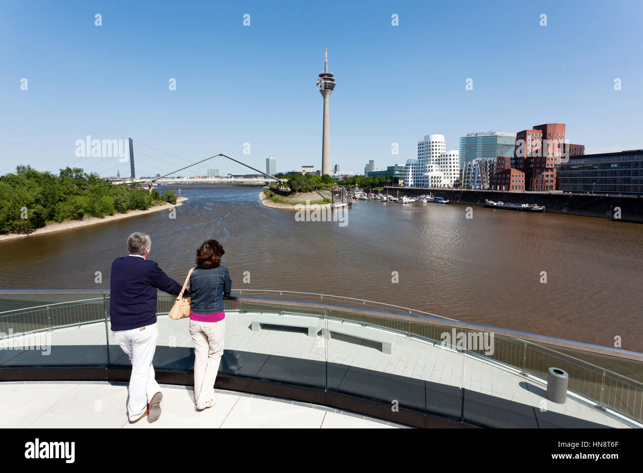 Dusseldorf, Germania - 1 Maggio 2011: un turista giovane godendo la vista dalla strada Hafenspitze attraverso il Medienhafen con costruzioni insolite. Foto Stock