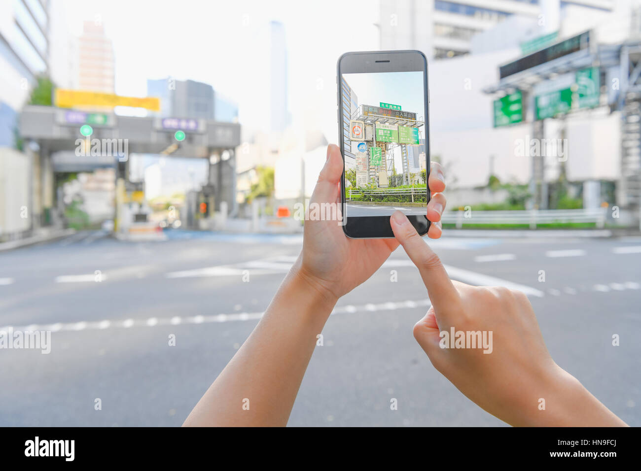 Donna Giapponese utilizzando augumented reality app sullo smartphone centro di Tokyo, Giappone Foto Stock