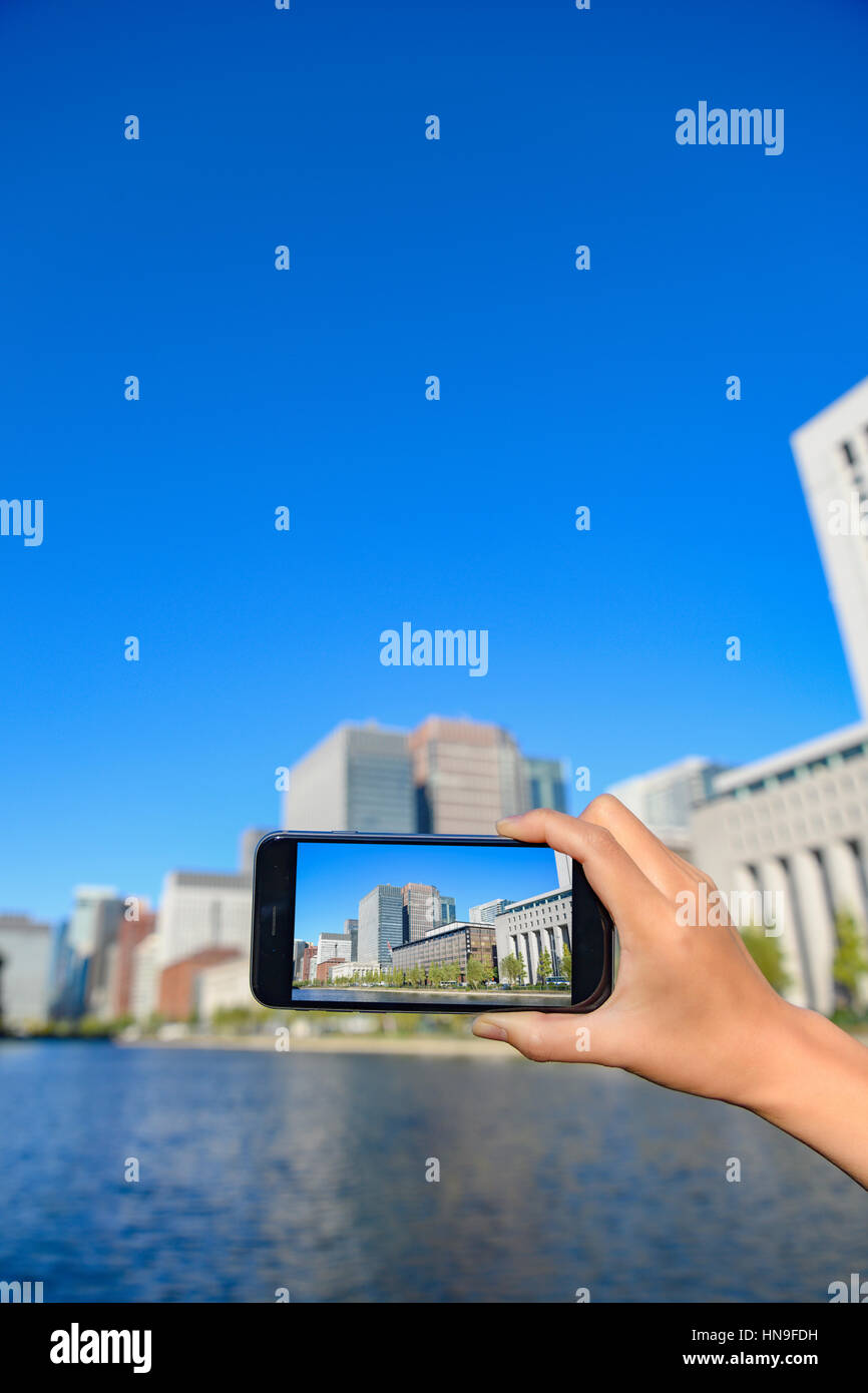 Donna Giapponese utilizzando augumented reality app sullo smartphone centro di Tokyo, Giappone Foto Stock