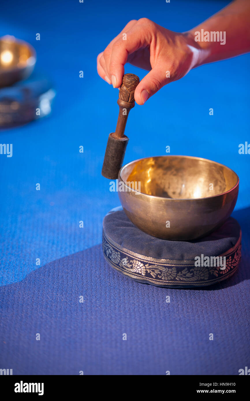 Close-up di un mulinello a mano e ciotola su uno sfondo blu. Foto Stock