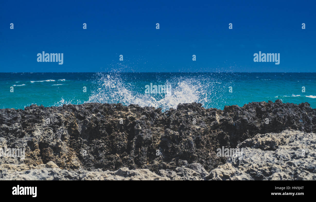 Sea Wave schiantarsi contro le rocce costiere nel Salento, Italia Foto Stock
