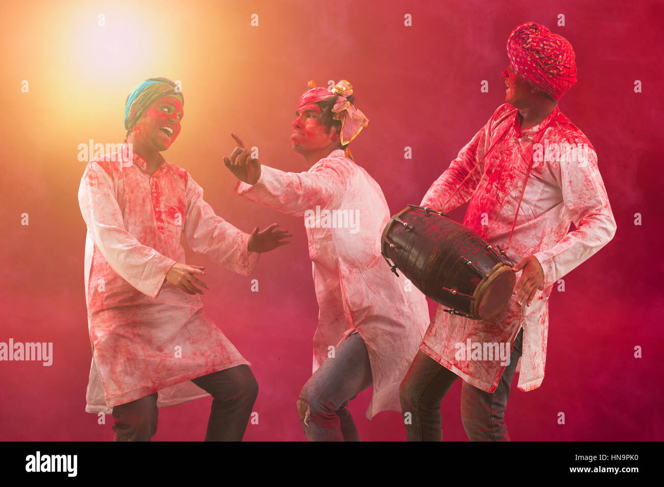 Tre giovani indiani gli uomini con la faccia colorata balli durante Holi festival a colori Foto Stock