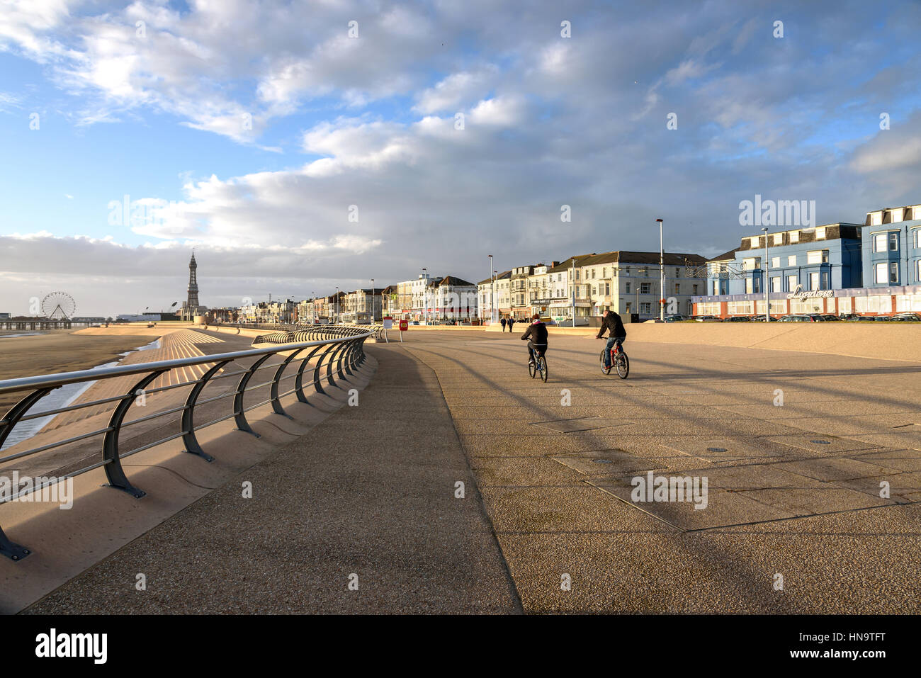 Coppia di piloti di bicicletta potranno godere di una corsa sulla South Promenade di Blackpool Beach, Inghilterra. Foto Stock