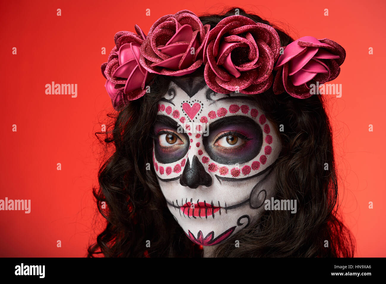 Ritratto di cranio make up viso sul rosso sfondo isolato Foto Stock