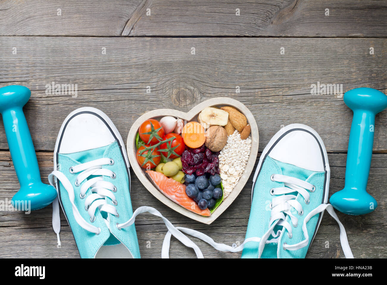 Uno stile di vita sano concetto con il cibo nel cuore e sport accessori fitness Foto Stock
