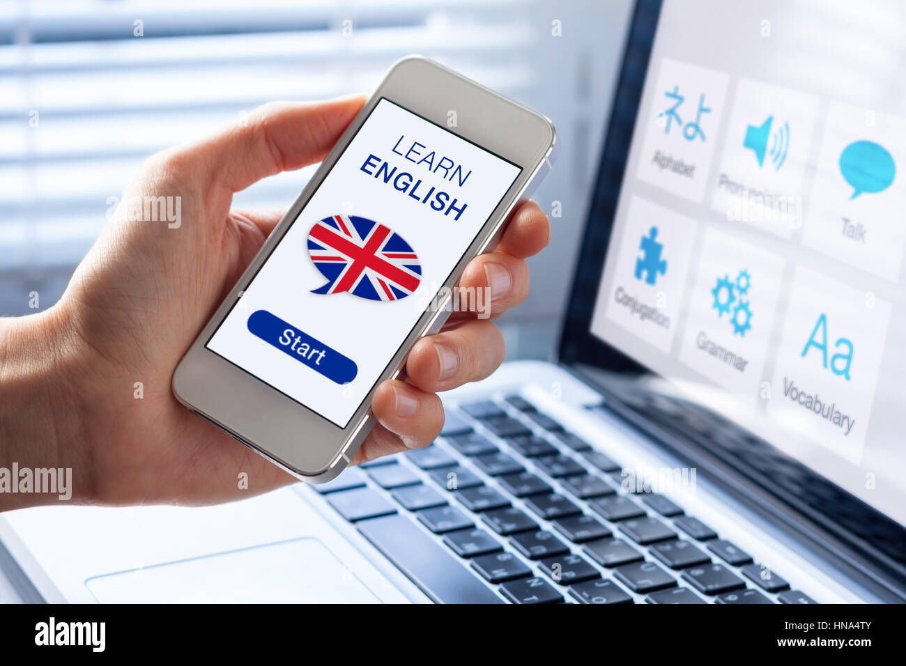 Imparare la lingua inglese in linea con il concetto di una persona che mostra l'e-learning app sul telefono cellulare con la bandiera britannica del Regno Unito Foto Stock