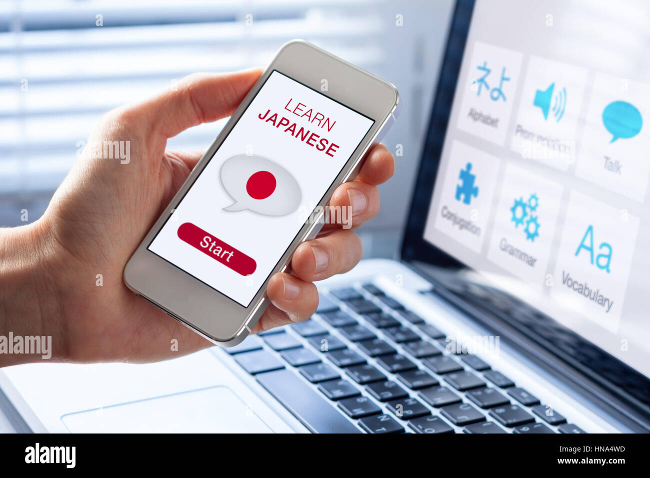 Imparare la lingua giapponese concetto online con una persona che mostra l'e-learning app sul telefono cellulare con la bandiera del Giappone Foto Stock