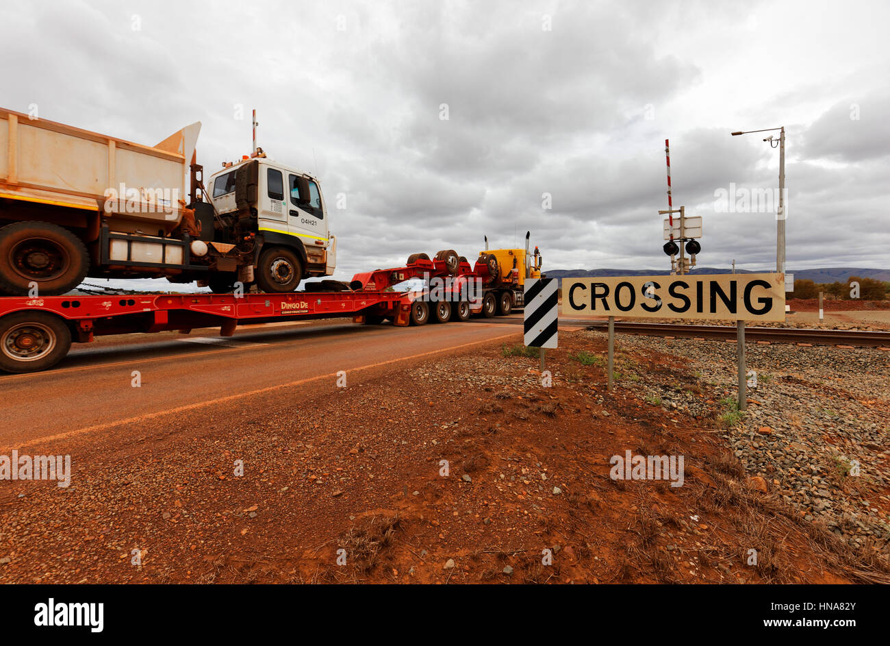 Road train carrello essendo guidato su un incrocio ferroviario, Pilbara, Western Australia. Foto Stock