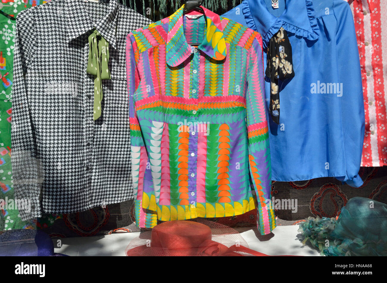 Multicolore, donna di camicetta in un negozio la finestra di visualizzazione Foto Stock