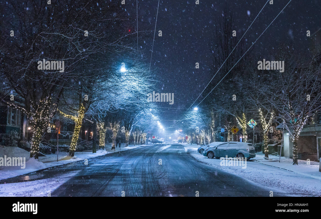 Strada con neve in area urbana di notte. Foto Stock