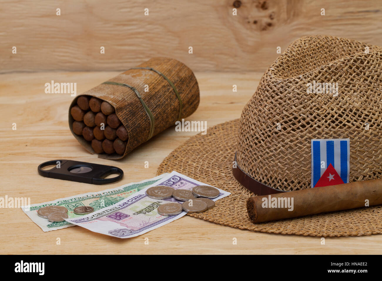 La Siesta - sigari, cappello di paglia e banconote cubano su un tavolo di legno Foto Stock