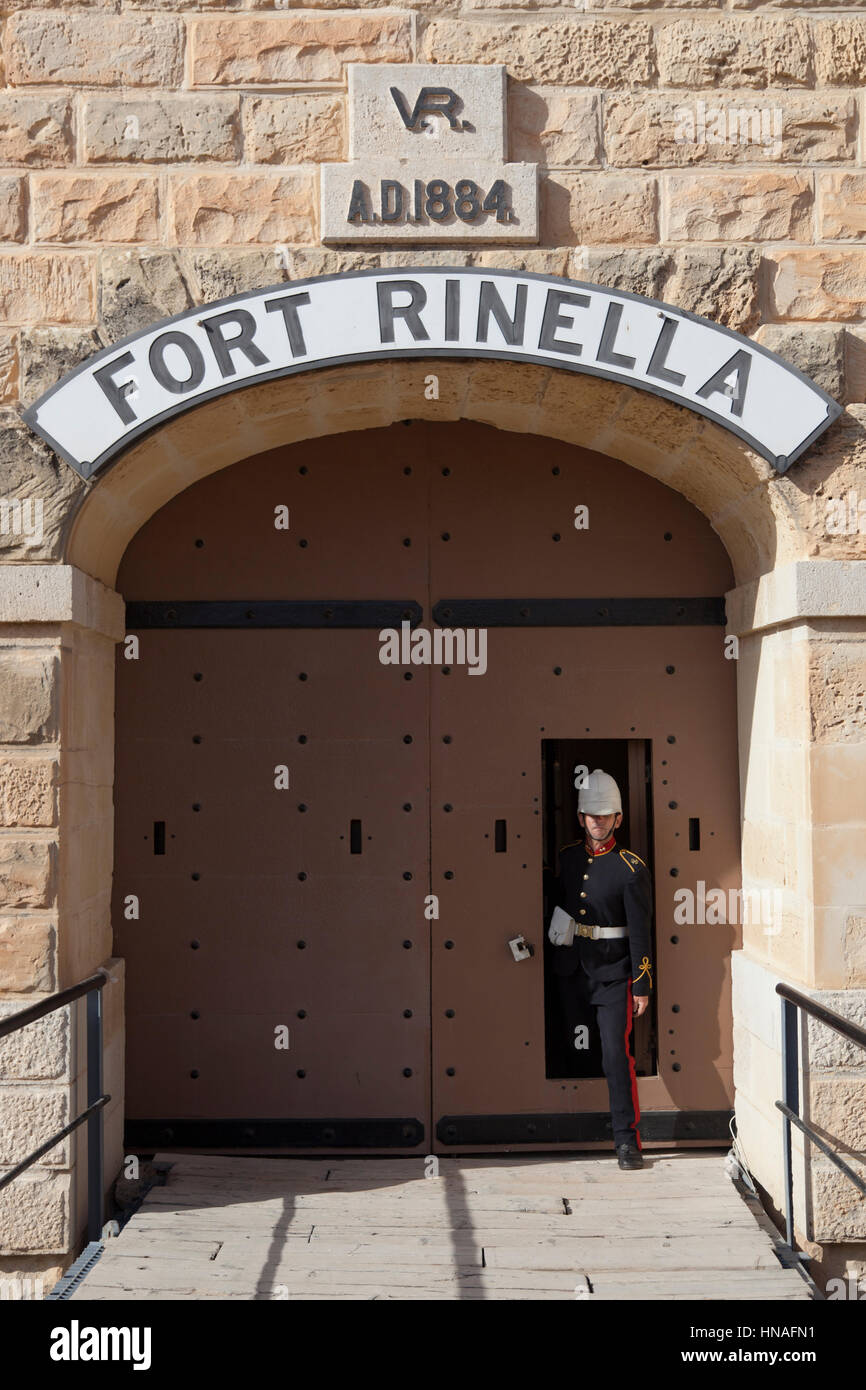 Una guida al sito nel periodo British uniforme militare di uscire dalla porta principale della Forte Rinella a Malta. Foto Stock