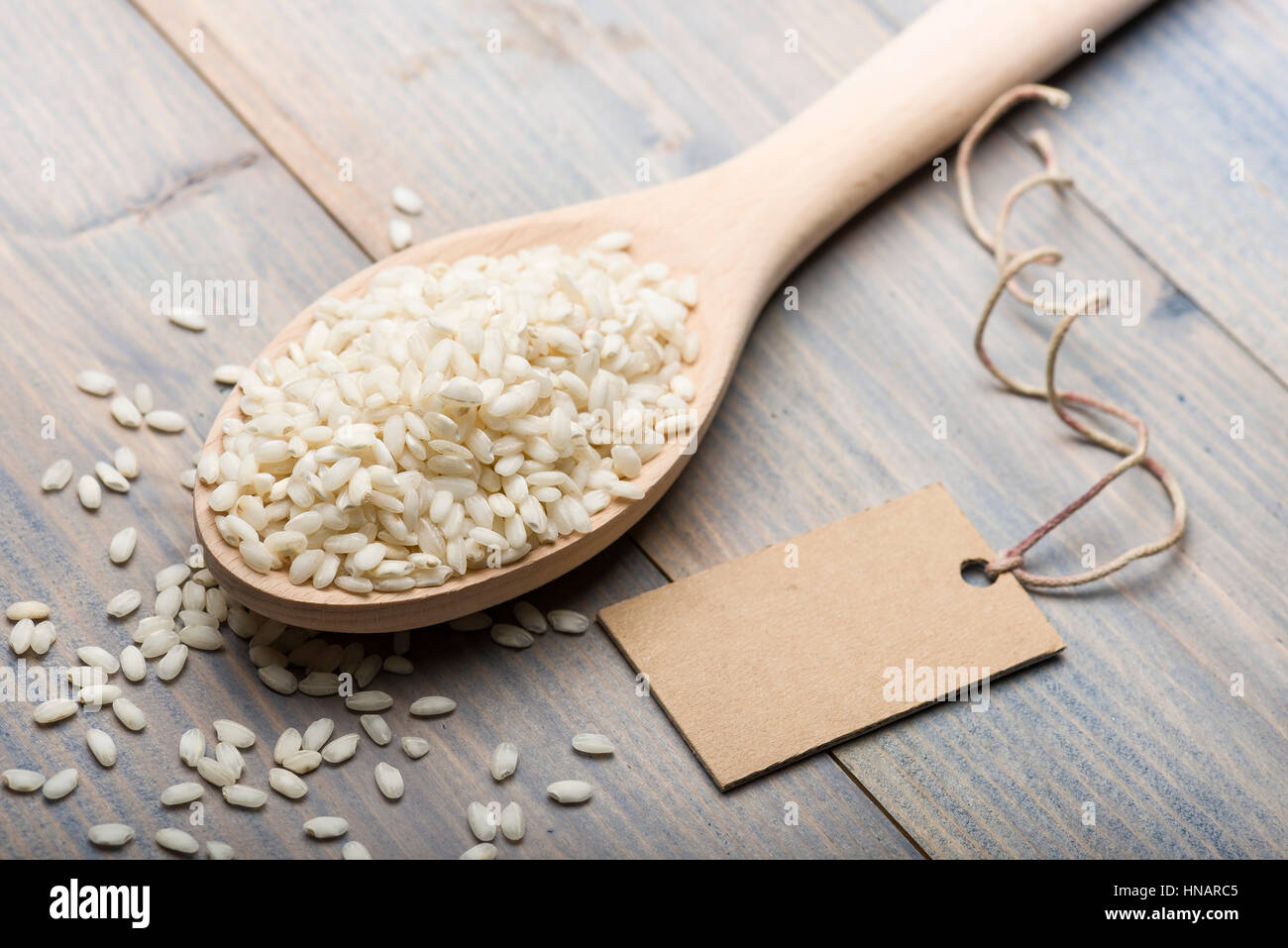 Cumulo di riso in bianco in cucchiaio di legno sul tavolo con etichetta di testo. Foto Stock